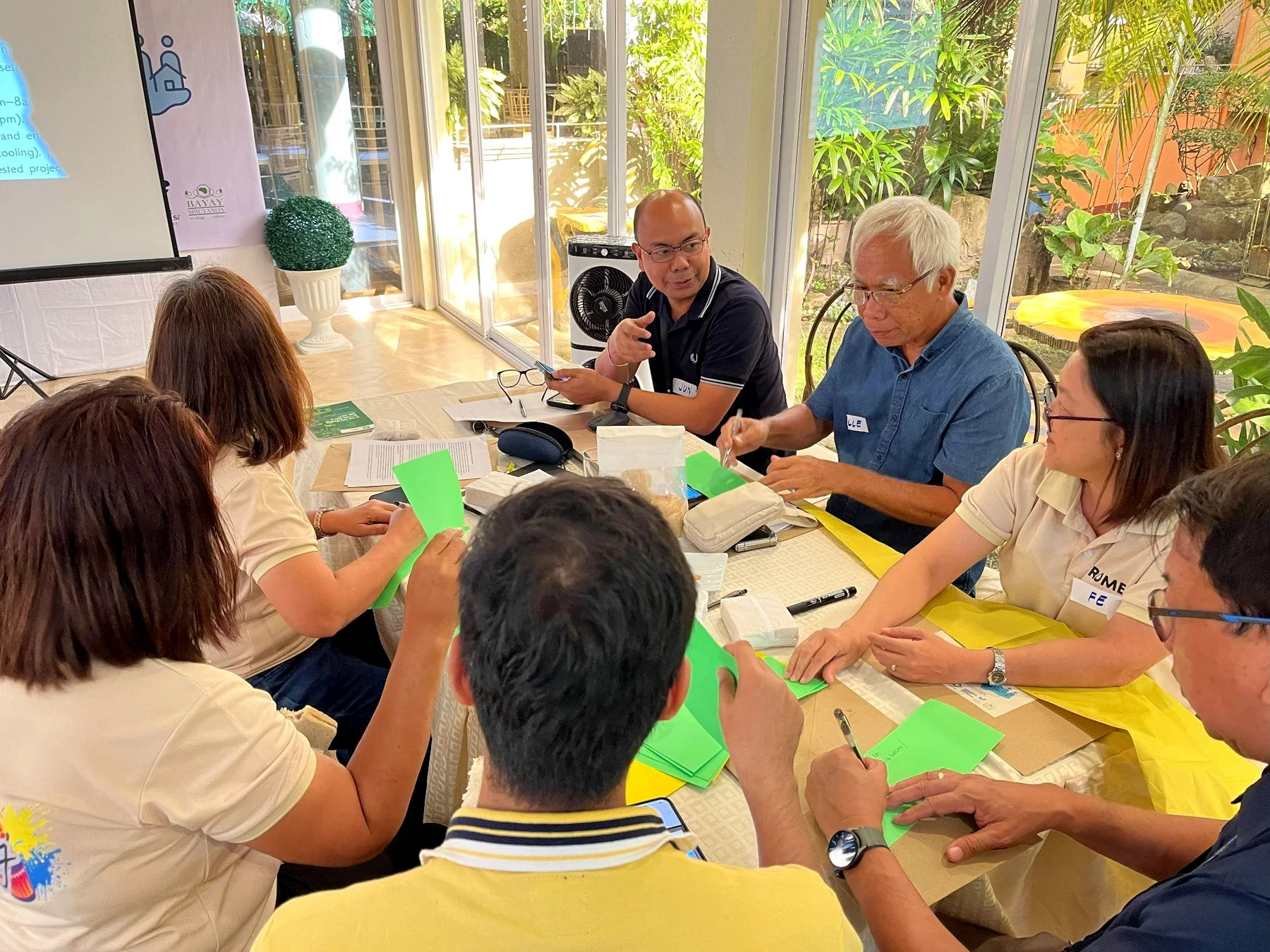 Participants discuss electricity priorities around a workshop table